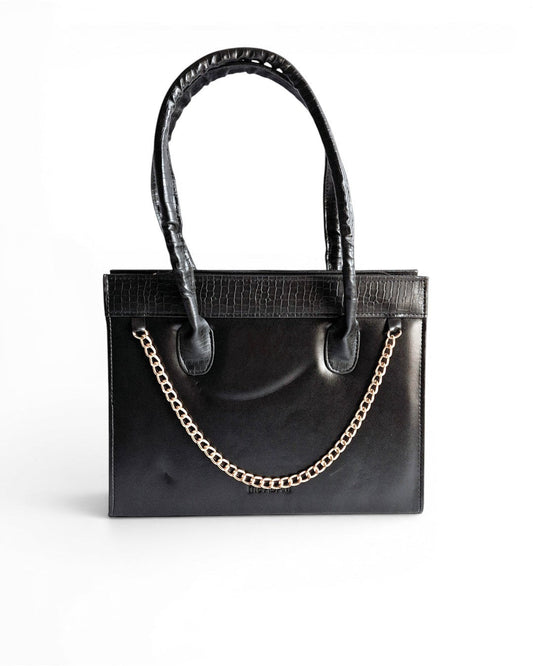 ms ADAM black faux leather top handle bag with gold chain detail and zip closure. Croc-embossed trim.