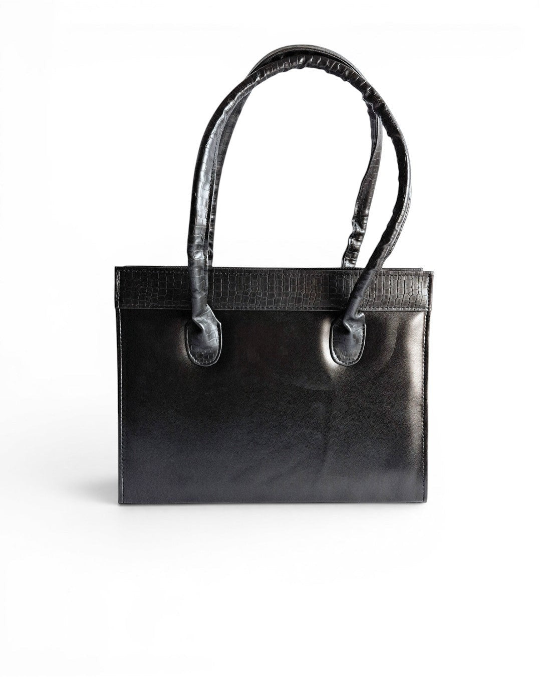 ms ADAM black faux leather top handle bag with zip closure and textured trim. Can be carried handheld or on the shoulder.