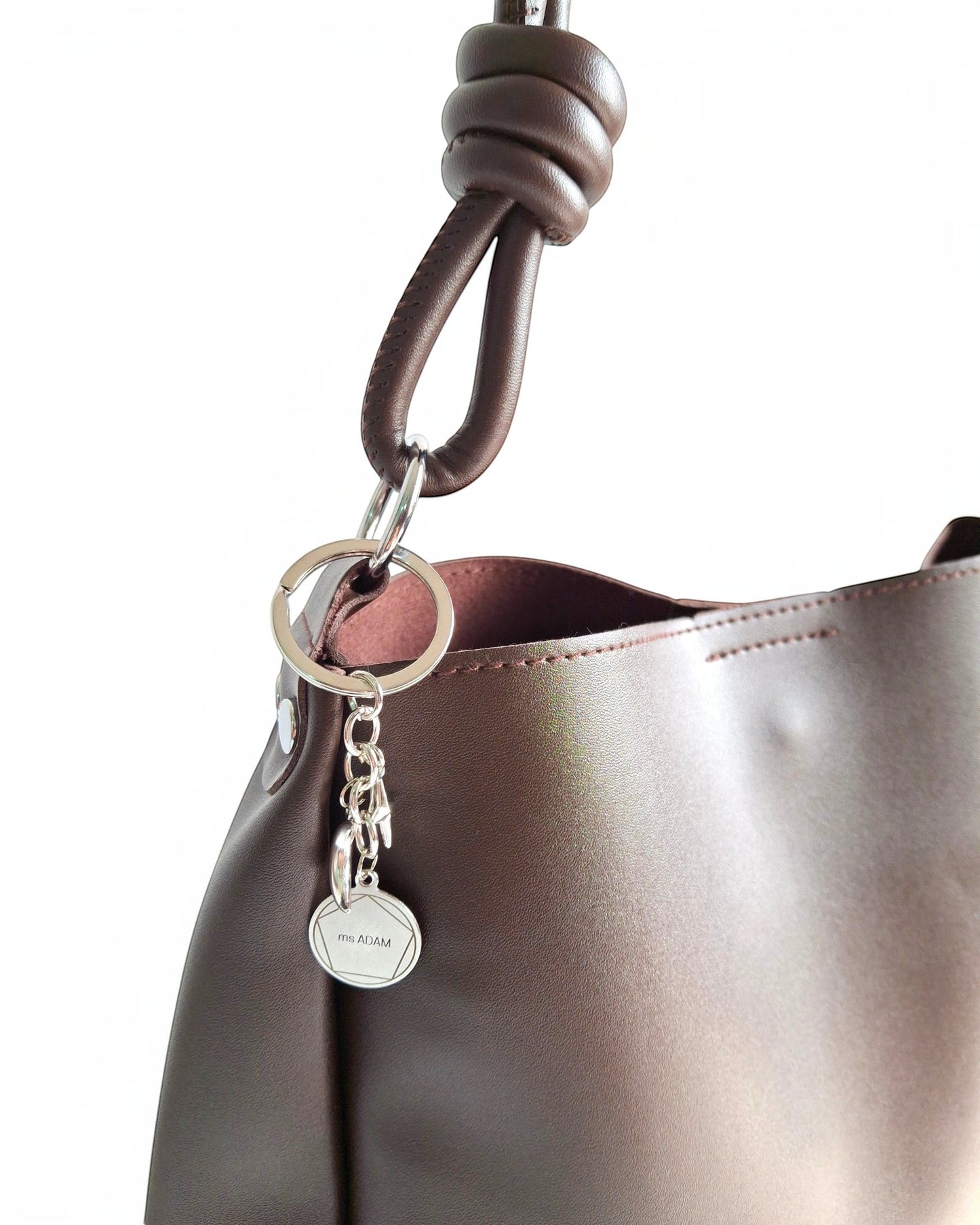 ms ADAM C Bean coffee brown faux leather shoulder bag with magnetic snap closure and keychain charm.